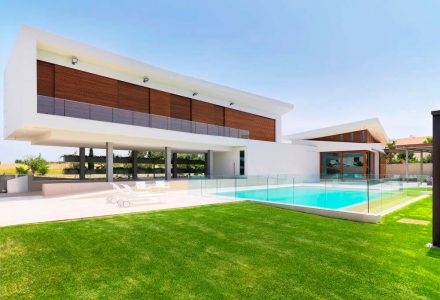 Outdoor house photo with garden and swimming pool.